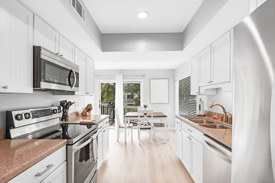 The eat-in kitchen has stone counters and hardwood floors.