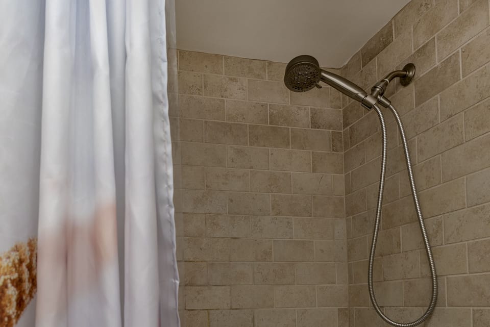 The bathroom has a tiled shower/tub.