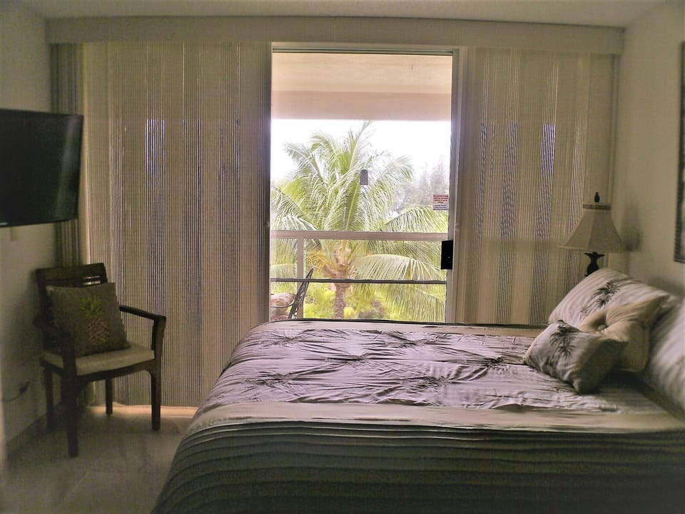 Studio Cal king bed with view out onto the lanai.