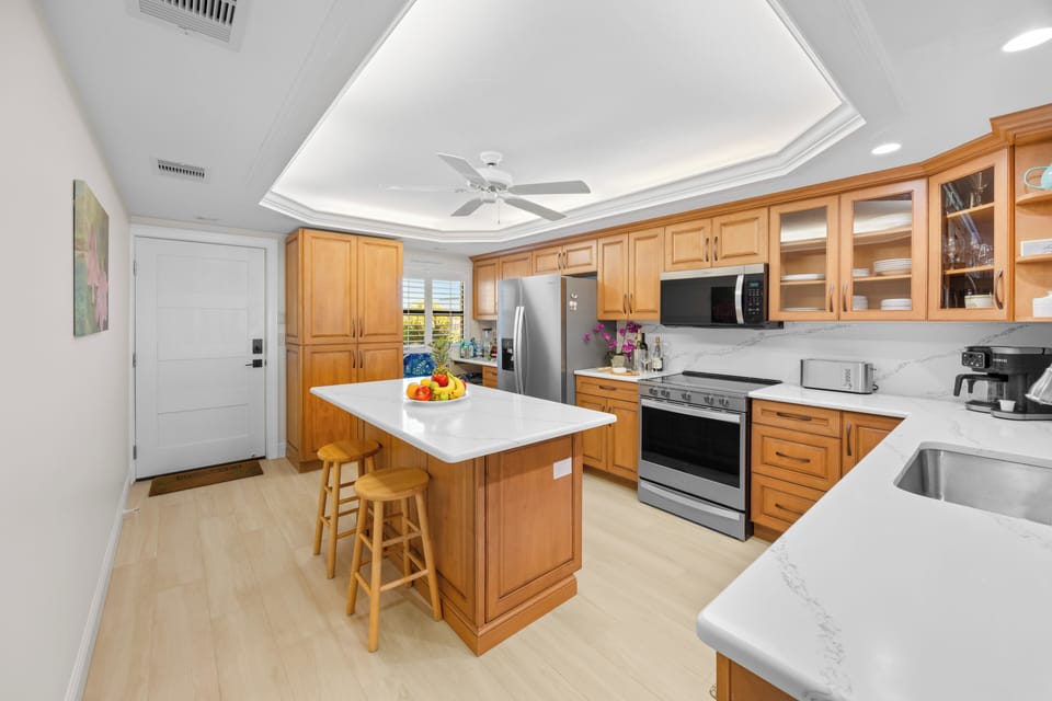Kitchen redesigned with new tile floors and quartz countertops and backsplash.
