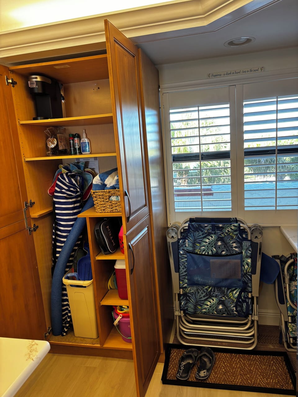Cabinet holds beach umbrellas and toys. Beach chairs and mat for sandy shoes.
