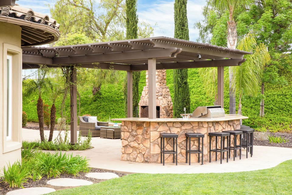 Outdoor fireplace lounge near the shaded grilling and bar area.