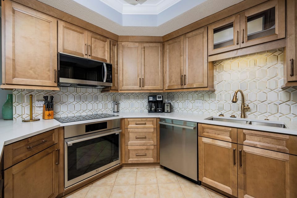 Craft your favorite meals surrounded by modern stainless appliances and wooden cabinetry on your coastal retreat