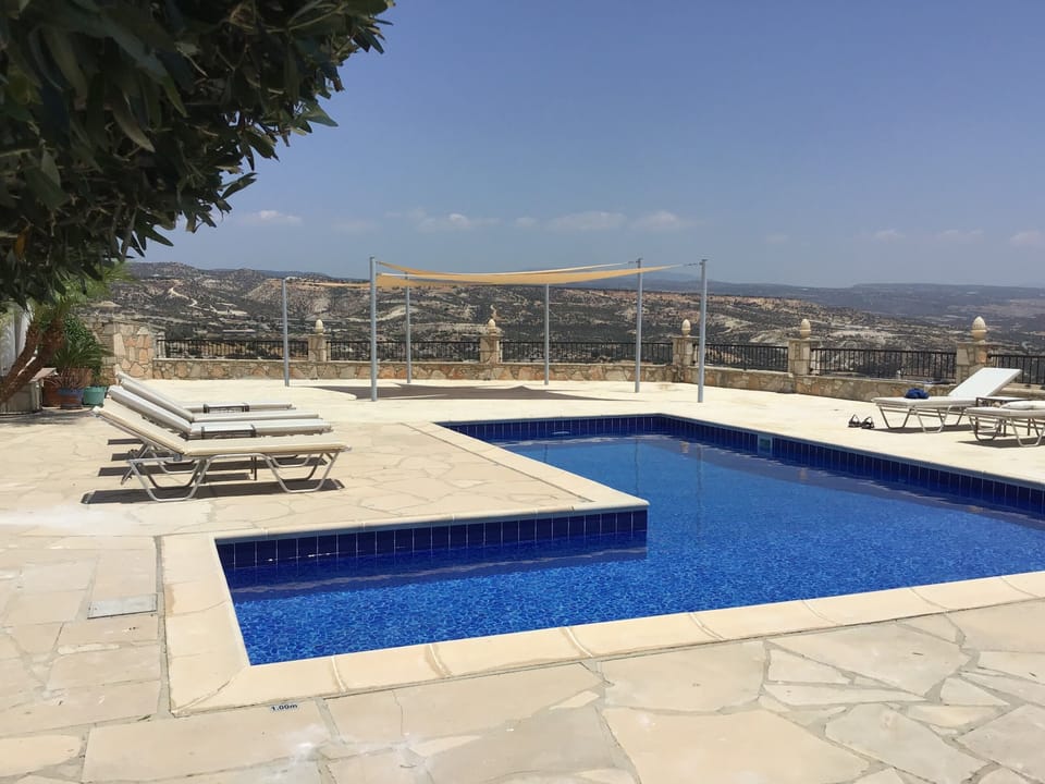 Poolside with shade sails and a hint of the wonderful view