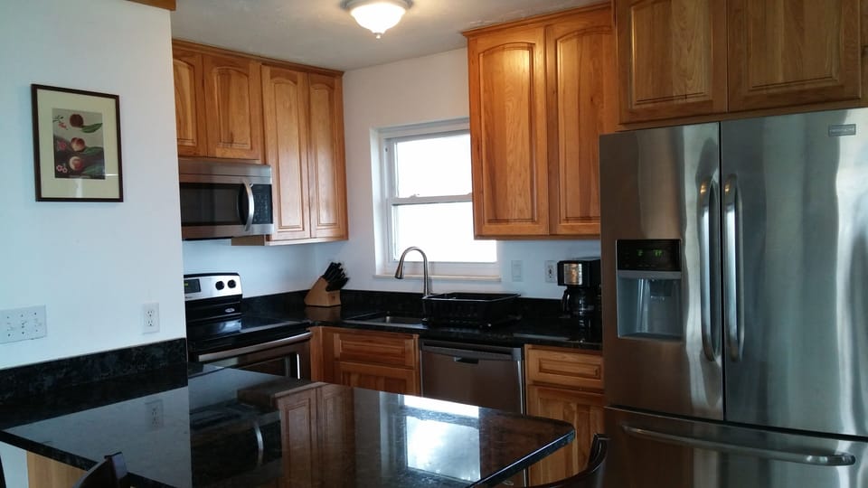 Kitchen with new hickory cabinets, stainless steel appliances, granite peninsula