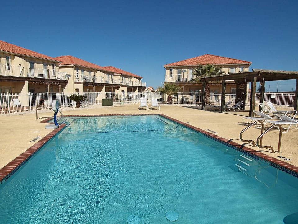 Pool at Aruba Condos with reclining chairs and a covered gazebo for shade.