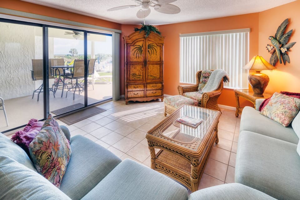 Living Room - Spacious living room with open floor plan and connected patio facing the pool and courtyard.