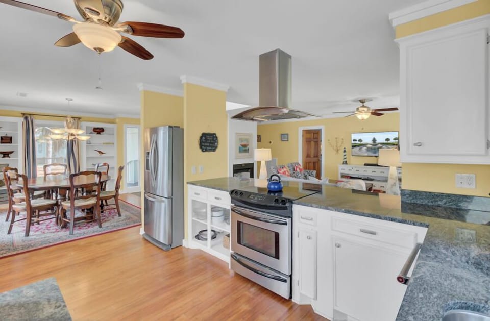 Cook and gather in your bright, fully equipped kitchen featuring granite counters, stainless appliances, and an open flow to the dining area.