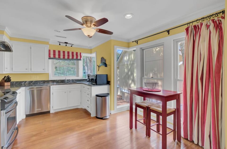 Your bright kitchen invites culinary adventures with cheerful yellow walls, white cabinets, and a cozy breakfast nook by sunny windows.