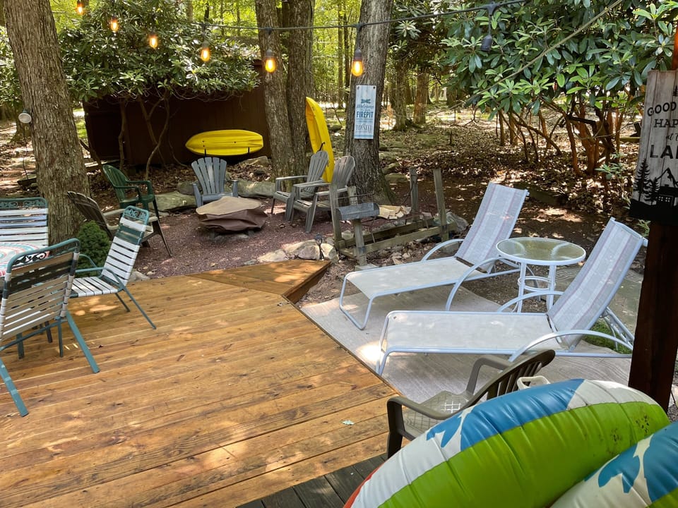 Fire pit, 2 yellow kids kayaks, table with 6 chairs, 2 chaise loungers