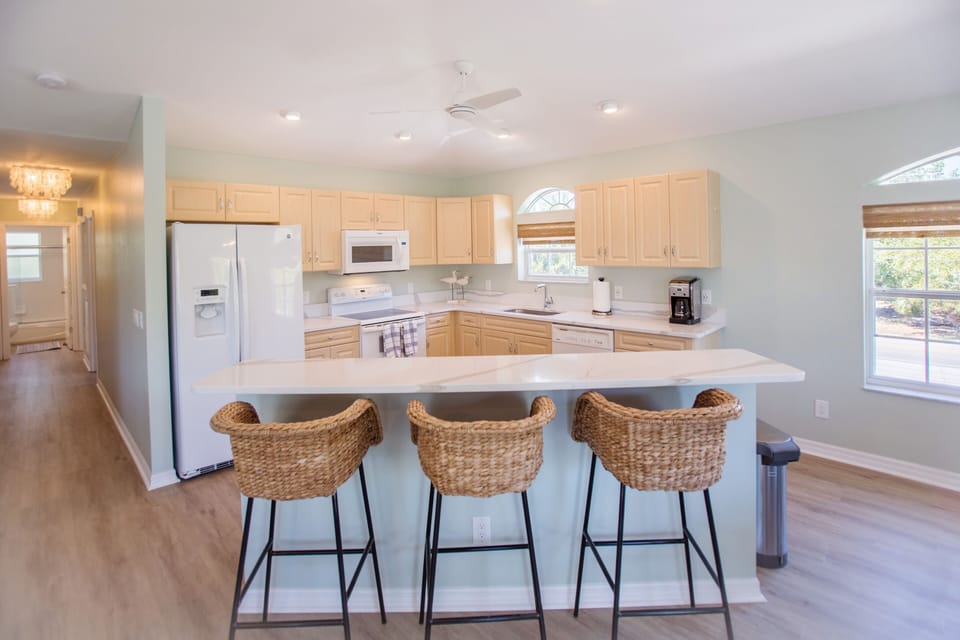 Seating for three at the open concept kitchen and bar area.  Beautiful countertops and cabinetry
