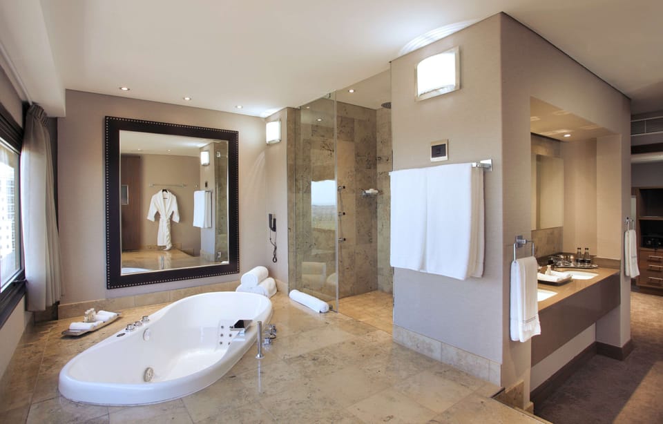 Sandton Sun Presidential Suite | Bathroom | Separate tub and shower, hydromassage showerhead, designer toiletries