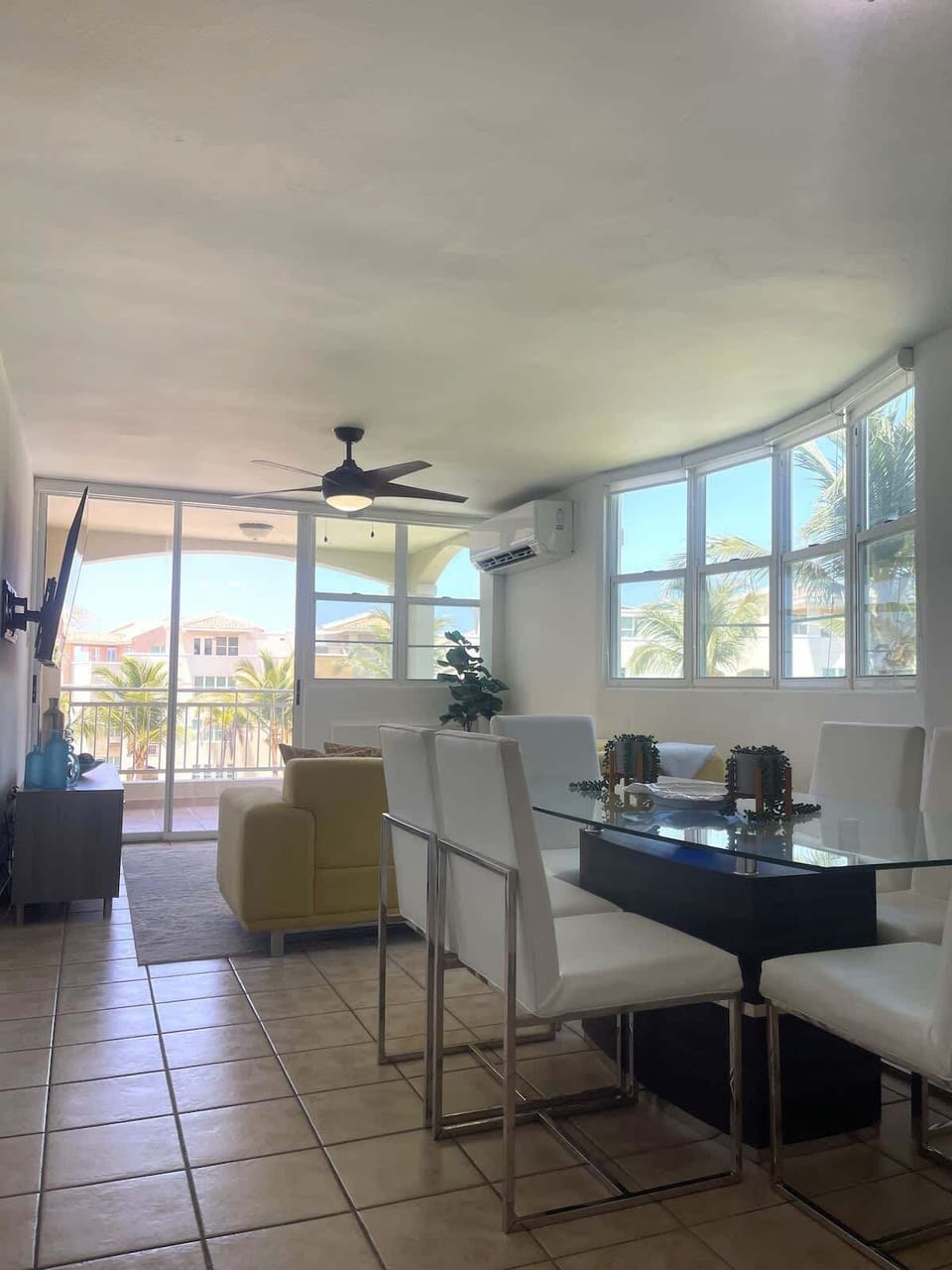 Spacious open-plan living, dining, and kitchen area with stunning views of the pool and beach.