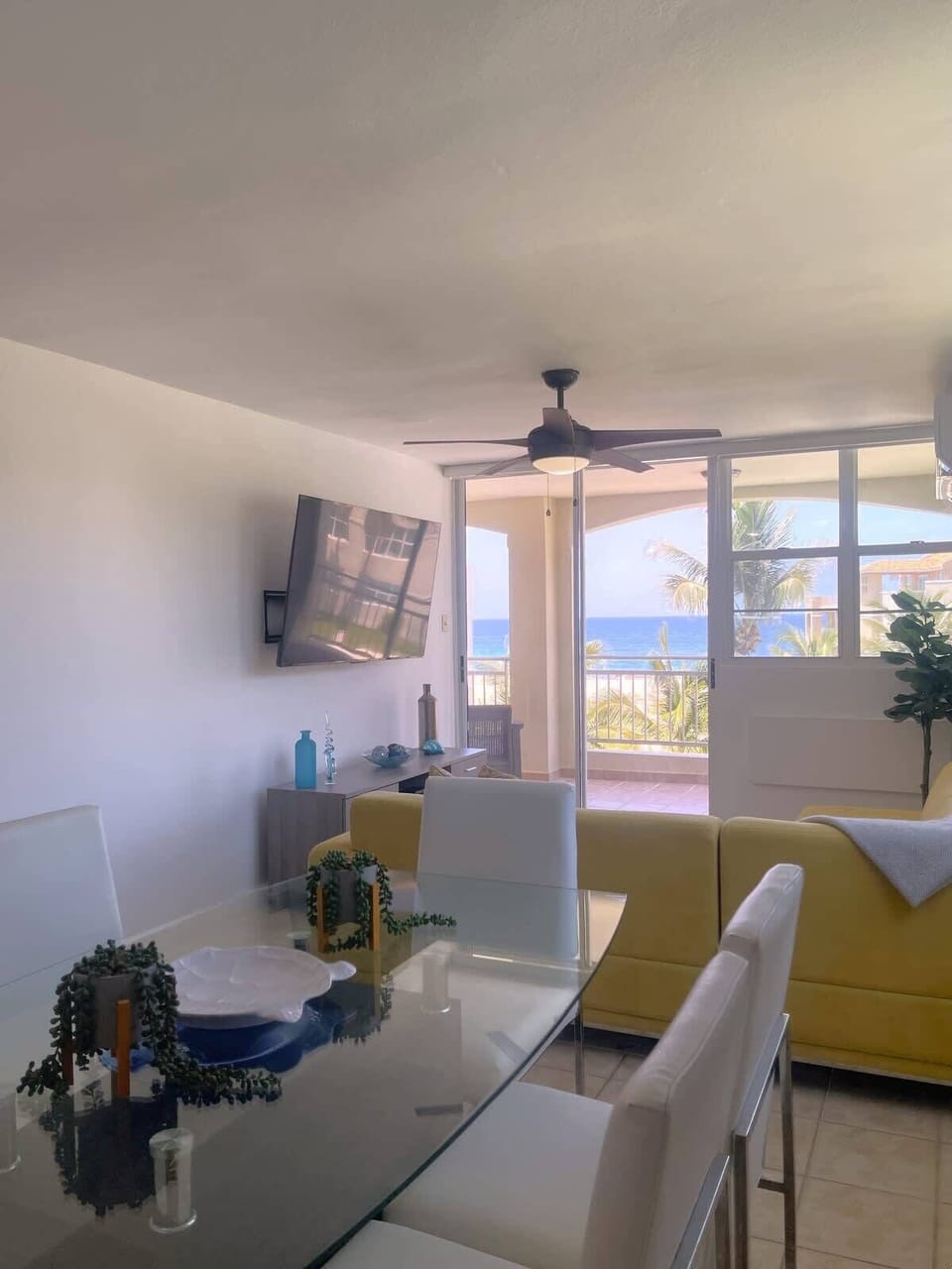 Spacious open-plan living, dining, and kitchen area with stunning views of the pool and beach.