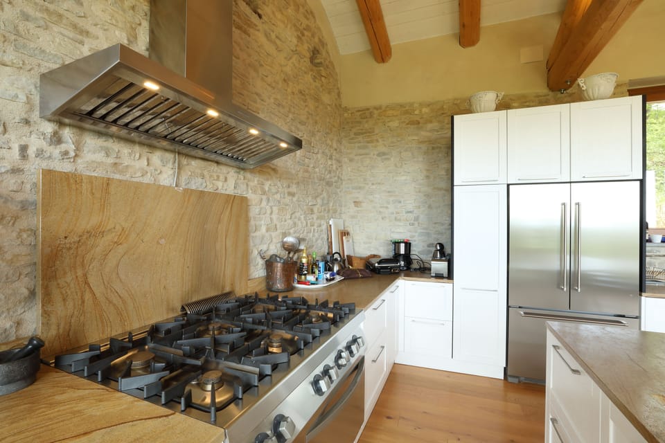 The 6 - burner professional stove in the large open kitchen