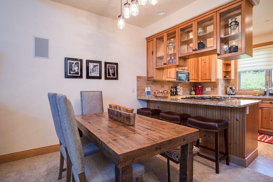 Gather around this rustic dining table where you'll share memorable meals, with warm wood finishes creating the perfect mountain retreat atmosphere.