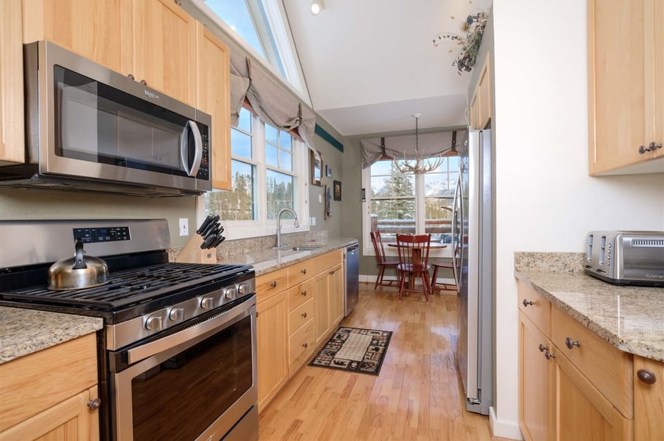 View of kitchen with granite counters, stainless appliances, views