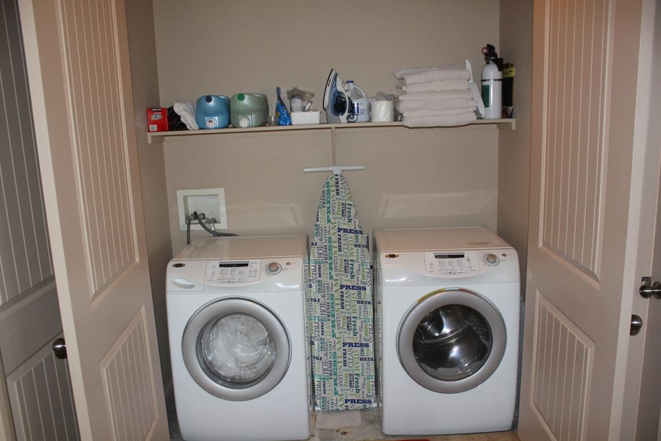 washer and dryer and ironing board in unit