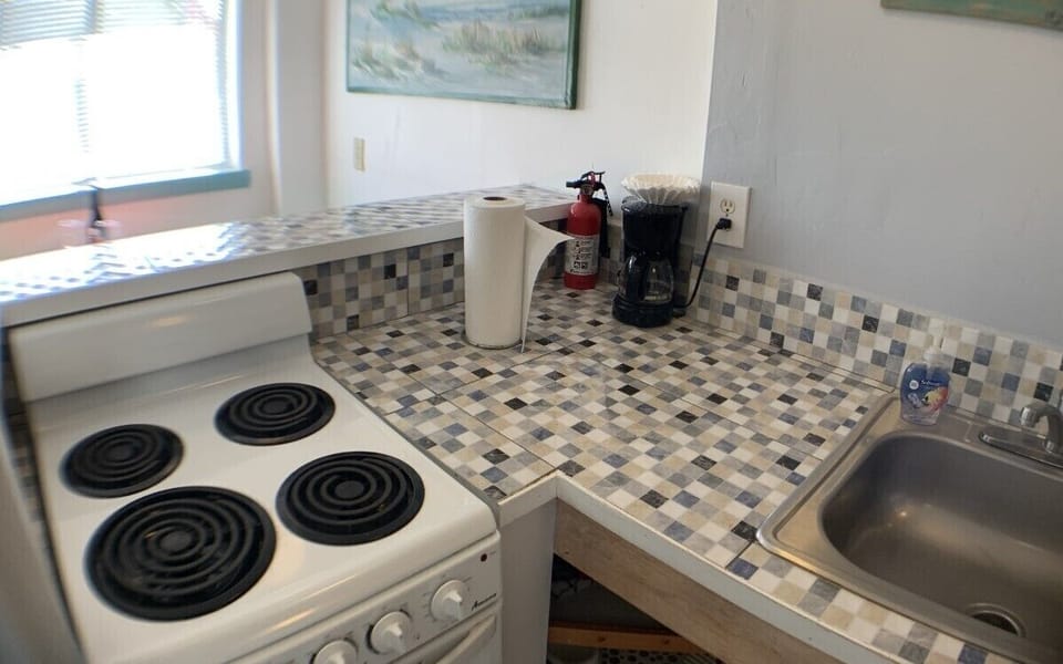 Kitchen details with porcelain tiles and stove with four burners on oven!