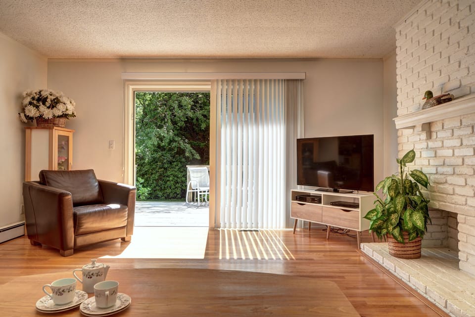 Sunlit living room with wide sliding glass doors that lead out to sundeck.