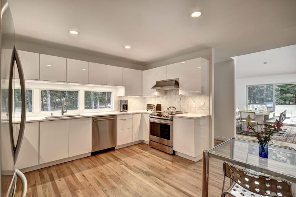 Modern, European-style kitchen with quartz counter tops and marble back splash.