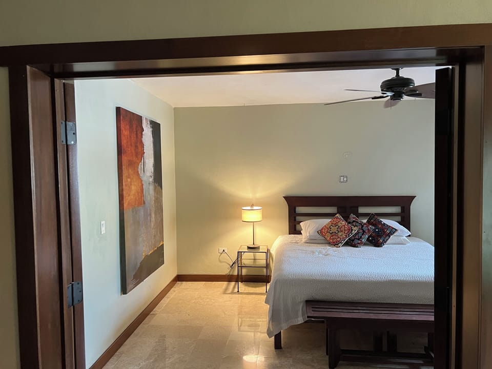 Inviting view from the living room into the bedroom suite with a king bed.