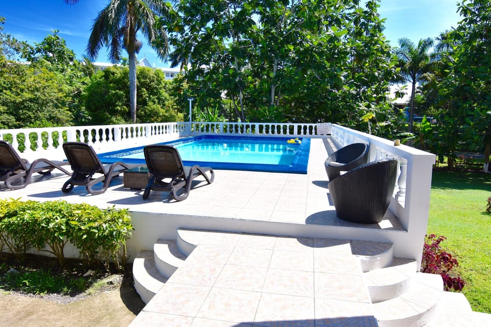 Swimming pool with four loungers also seating there is a BBQ pit on the left 