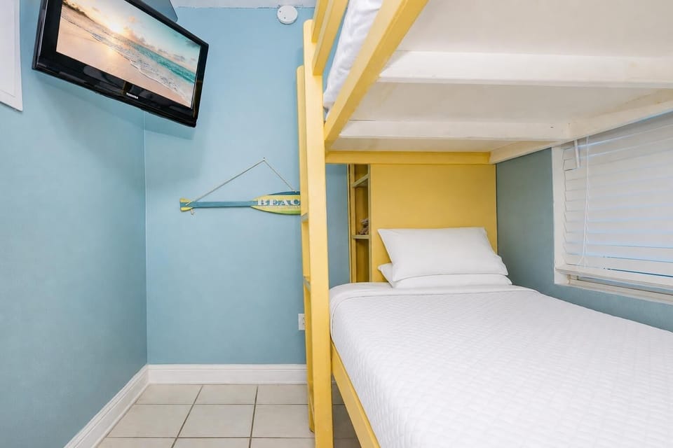 Gentle coastal hues surround the bunk bed in the sleeping area where you rest and watch your favorite show