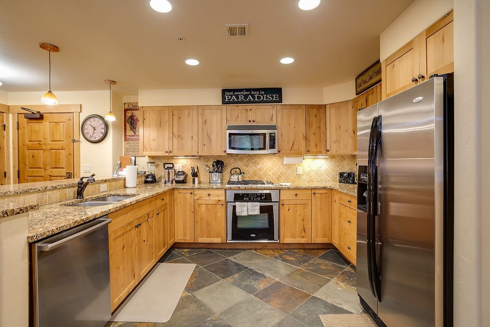 You'll love cooking in this spacious kitchen with granite counters, stainless steel appliances, and warm wood cabinets.