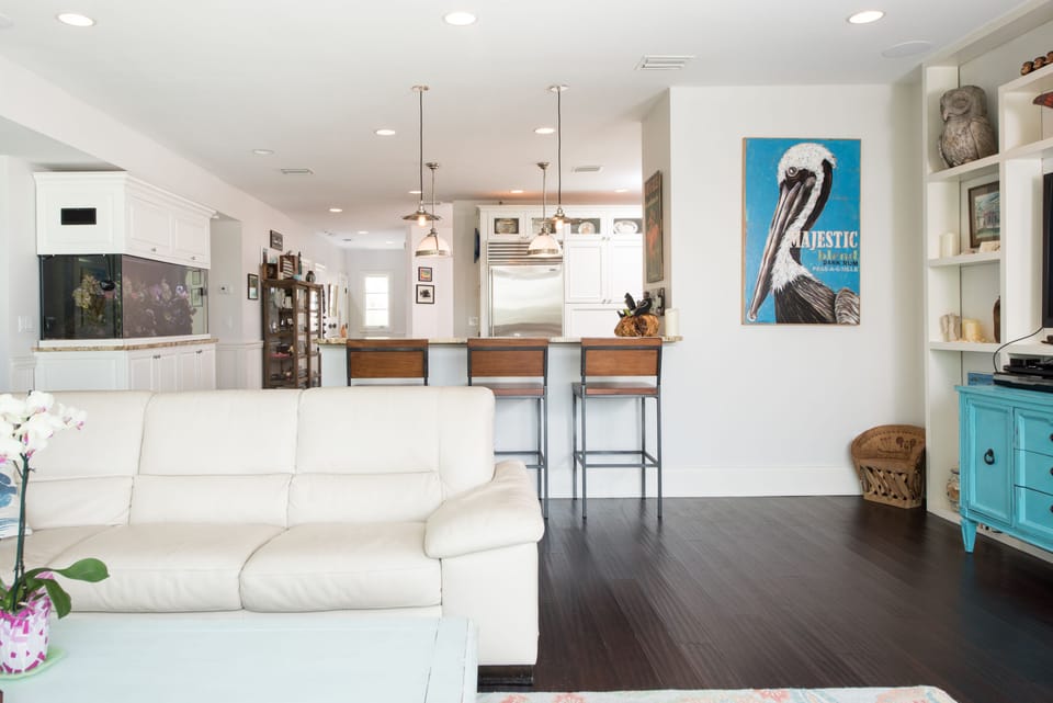 view back from the living room toward kitchen and dining room behind it