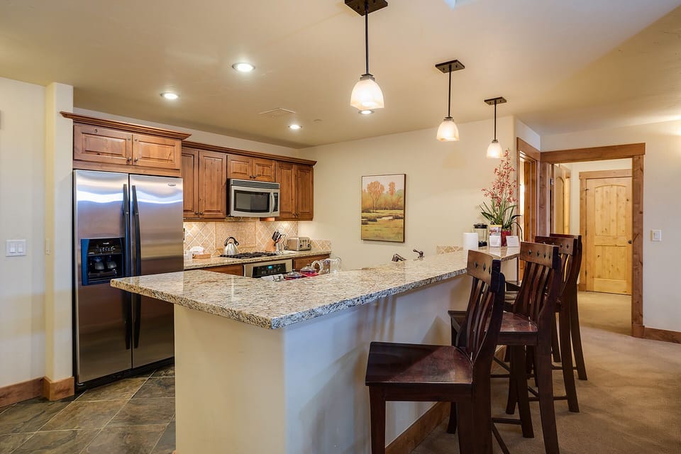 Your fully-equipped kitchen features granite countertops, stainless steel appliances, and a breakfast bar where you can enjoy morning coffee together.