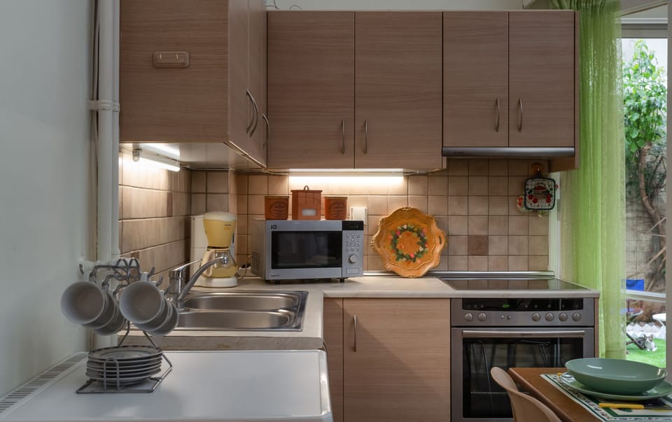 Fitted kitchen with an oven, glass stovetop, microwave, and coffee machine