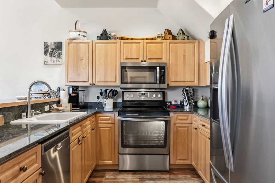 Cook your favorite meals in this fully equipped kitchen with stainless appliances, granite counters, and warm wood cabinets.