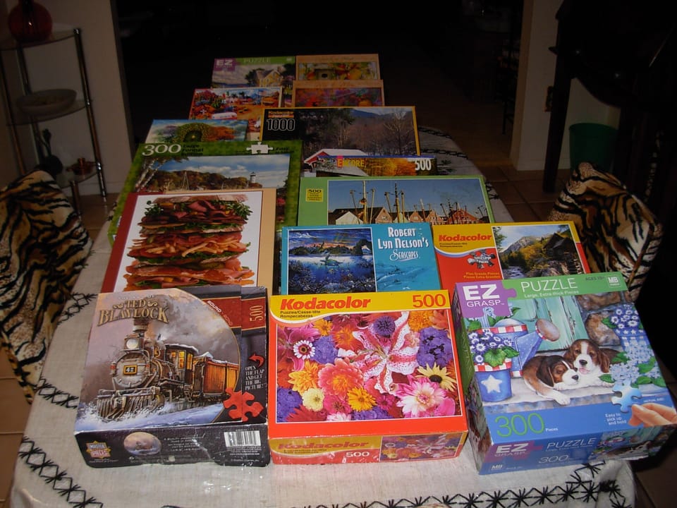 22 picture puzzles waiting for guests to assemble.