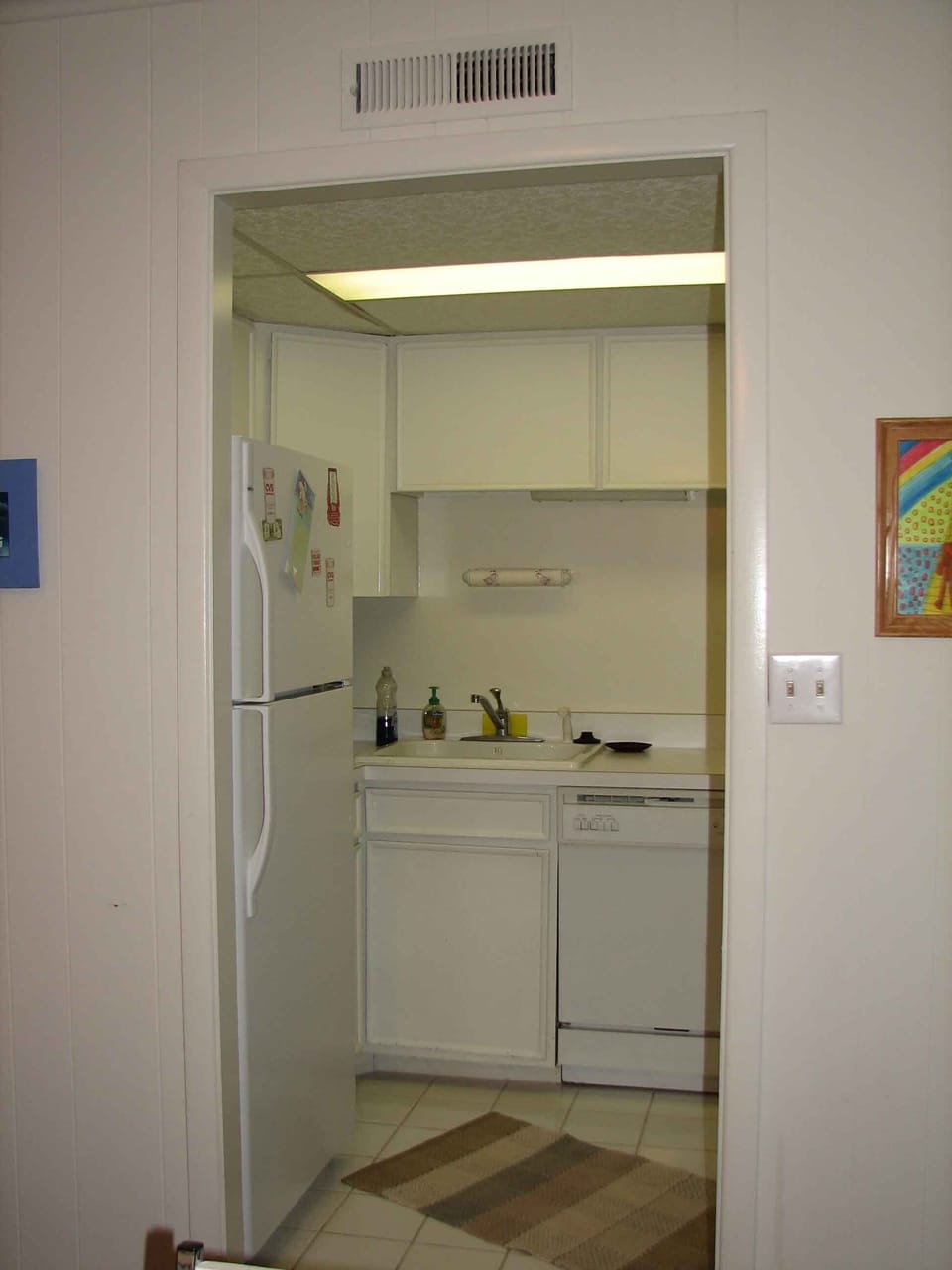 The kitchen is equipped with dishes, cookware, coffee maker, microwave, toaster.