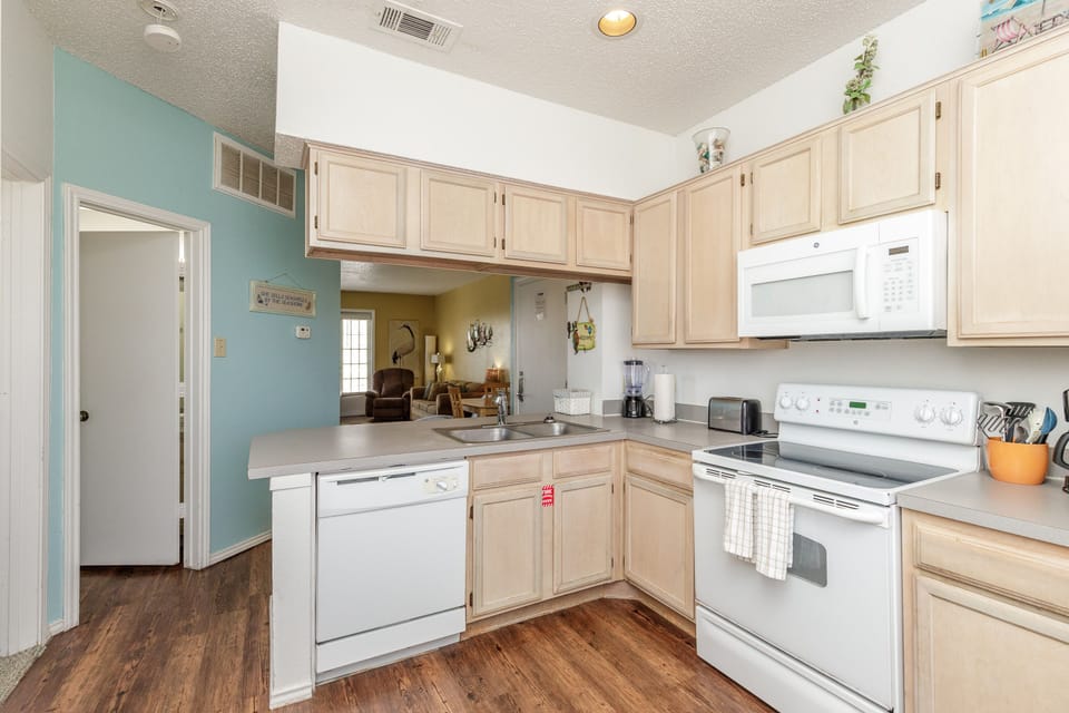 Your fully equipped kitchen features warm wood cabinets, modern appliances, and opens to the living area for easy entertaining.