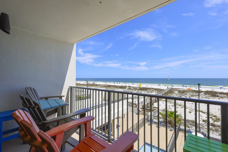 Relax on the colorful chairs of this balcony with a stunning beachfront view, perfect for enjoying the coastal breeze