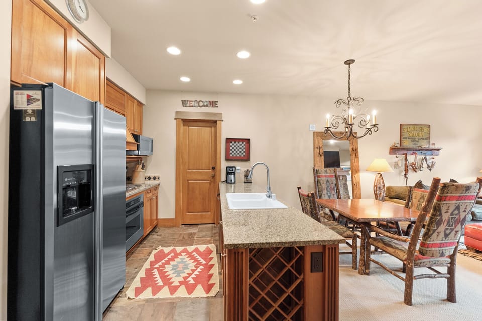Your spacious kitchen features warm wood cabinetry, granite counters, and stainless appliances, flowing seamlessly into your cozy dining area.