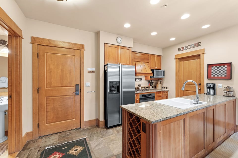 Cook your favorite meals in this warm kitchen featuring granite counters, stainless appliances, and rich wood cabinetry.