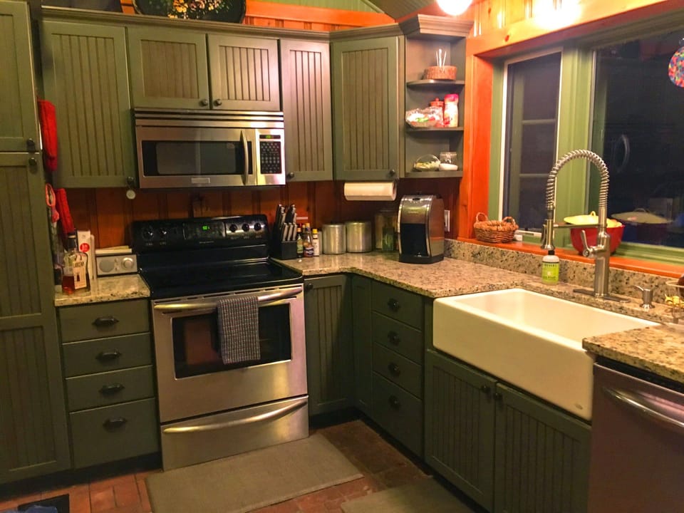 Modern kitchen with farmhouse sink, stainless steel appliances, cooking supplies