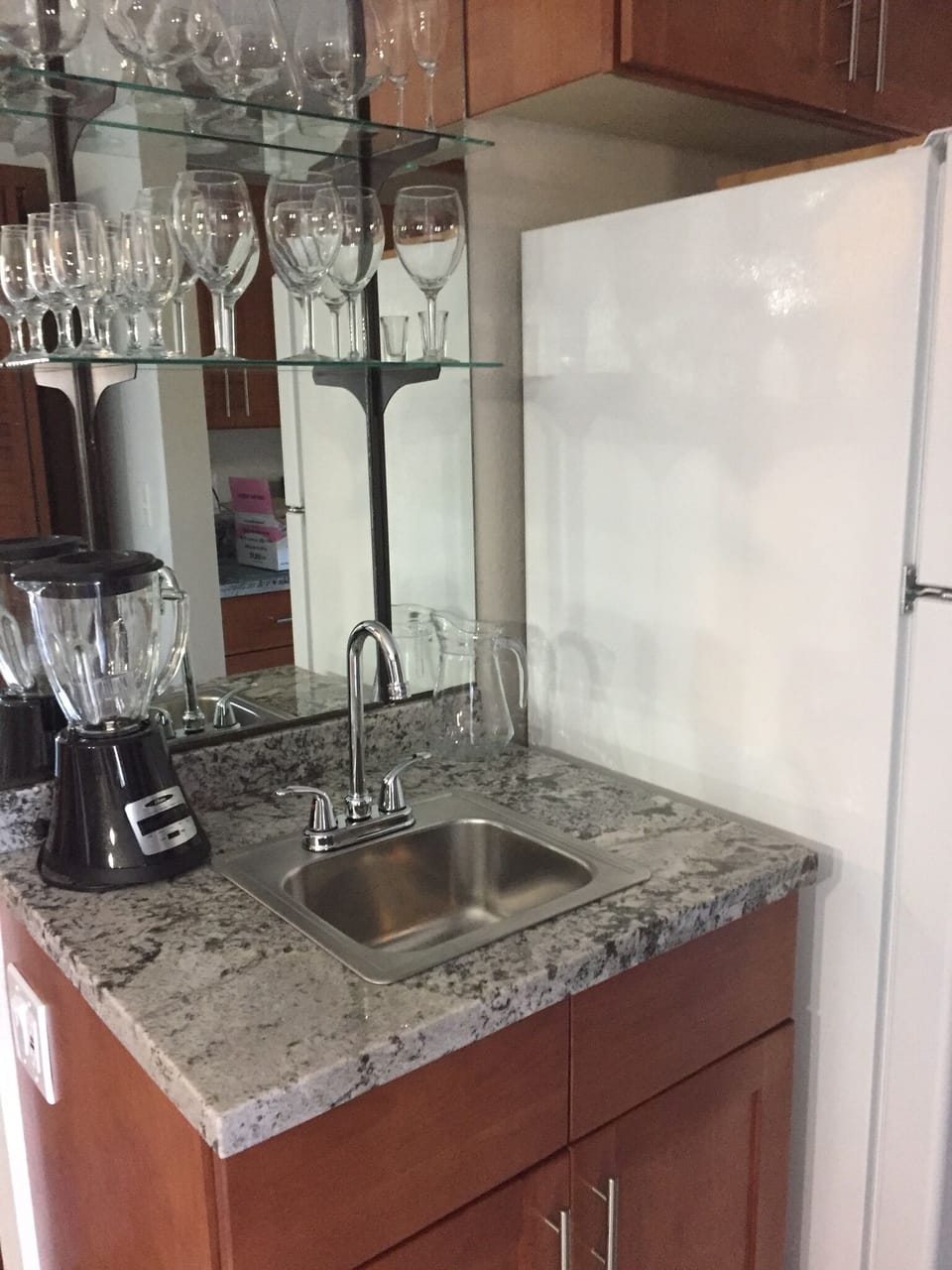 Bar sink has had updated glassware with plenty of storage for a bar. 