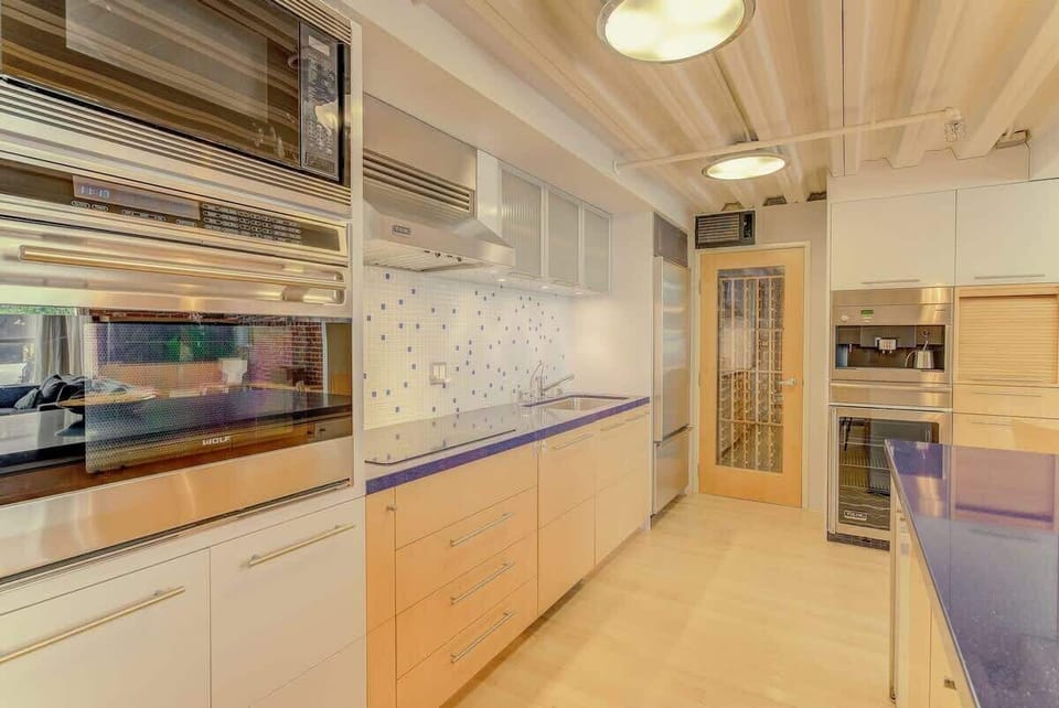 Sleek gourmet kitchen with stainless appliances, custom cabinetry, and warm lighting—perfect for effortless cooking and entertaining.
