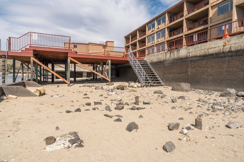 Beachfront property with direct beach access via private stairs and elevated deck overlooking the sandy shoreline.