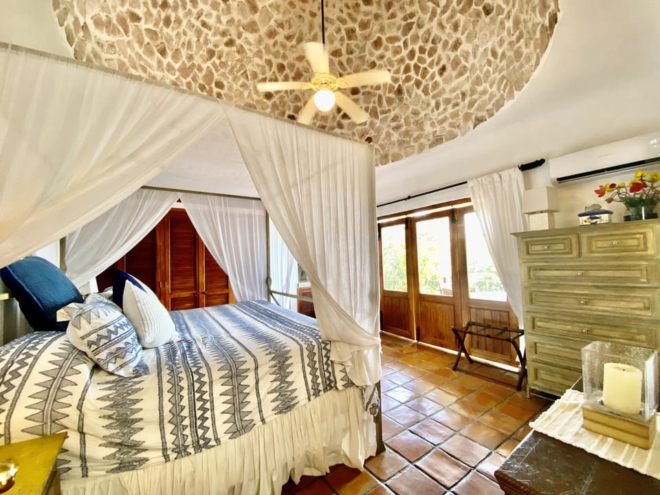 Master bedroom includes a king size bed, ceiling fan, balcony, and bathroom