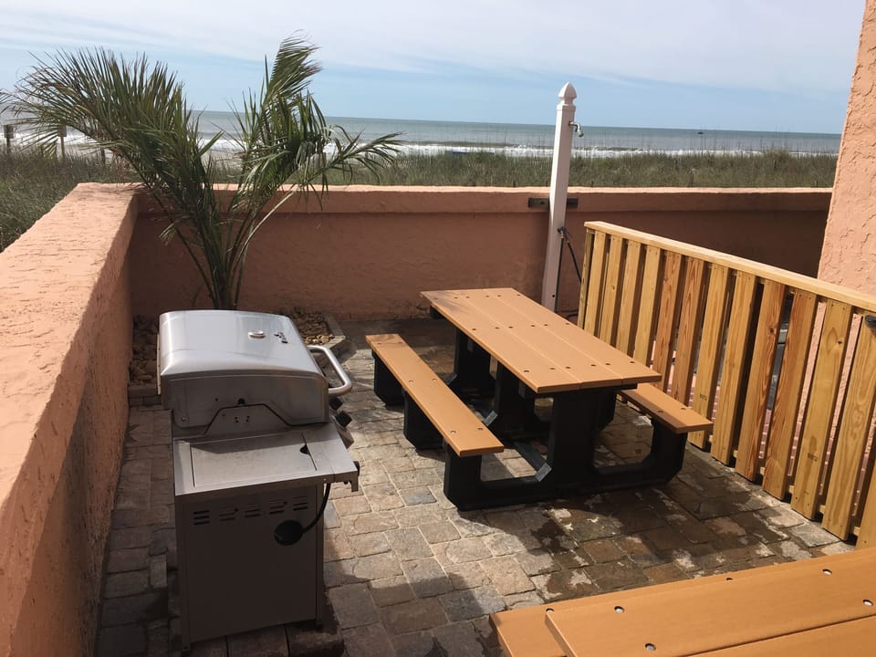 Outdoor grilling area with picnic tables.