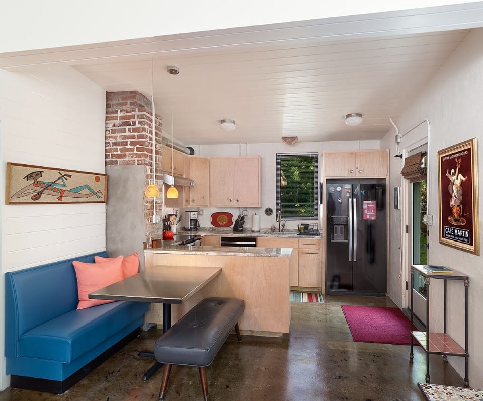 The kitchen and dining area provide a custom dining table and benches with custom cabinets and everything you would need to cook and serve meals.