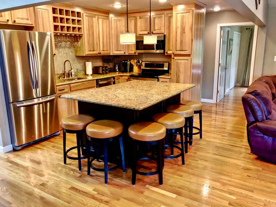 Living/Dining Area: Beautiful open concept space with large dining table that seats 10 and modern, comfortable furniture that surrounds the impressive stone fireplace.