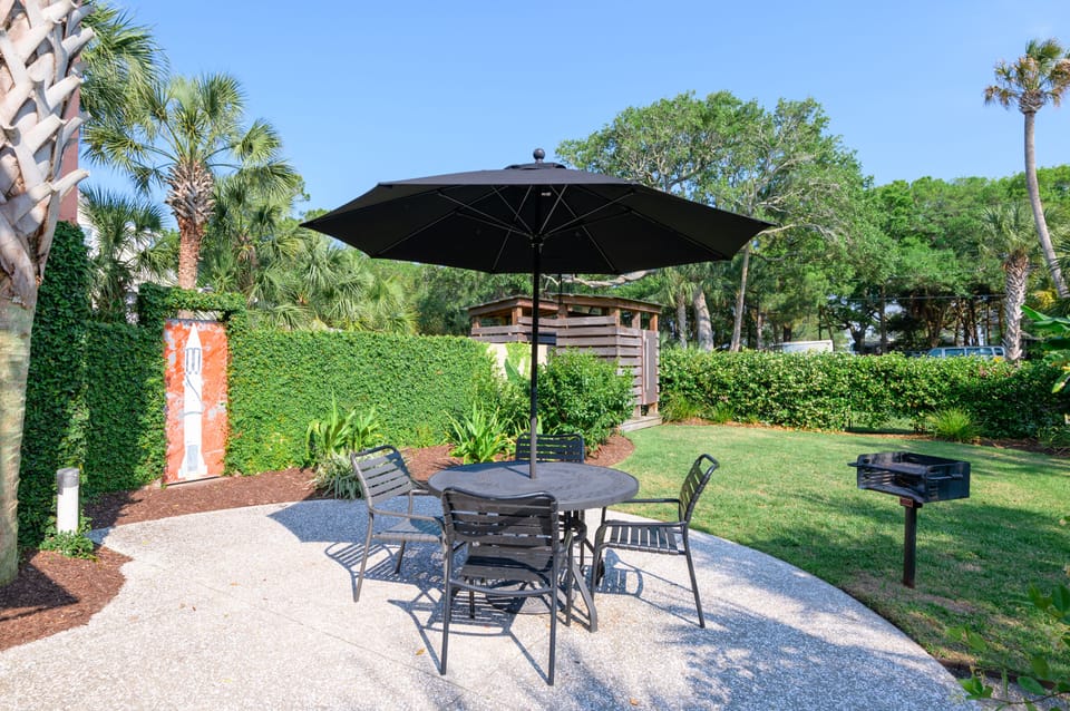 4 person outdoor dining area with umbrella and additional seating. The beautifully landscaped yard also has a private hot/cold outdoor rain shower and charcoal grill.