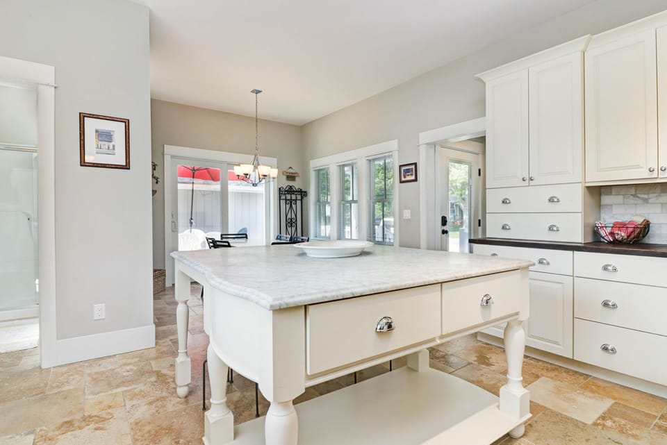 Natural travertine tile flooring is installed throughout the kitchen.