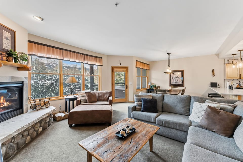 Living Room: L-shaped couch, plush armchair, TV, gas fireplace